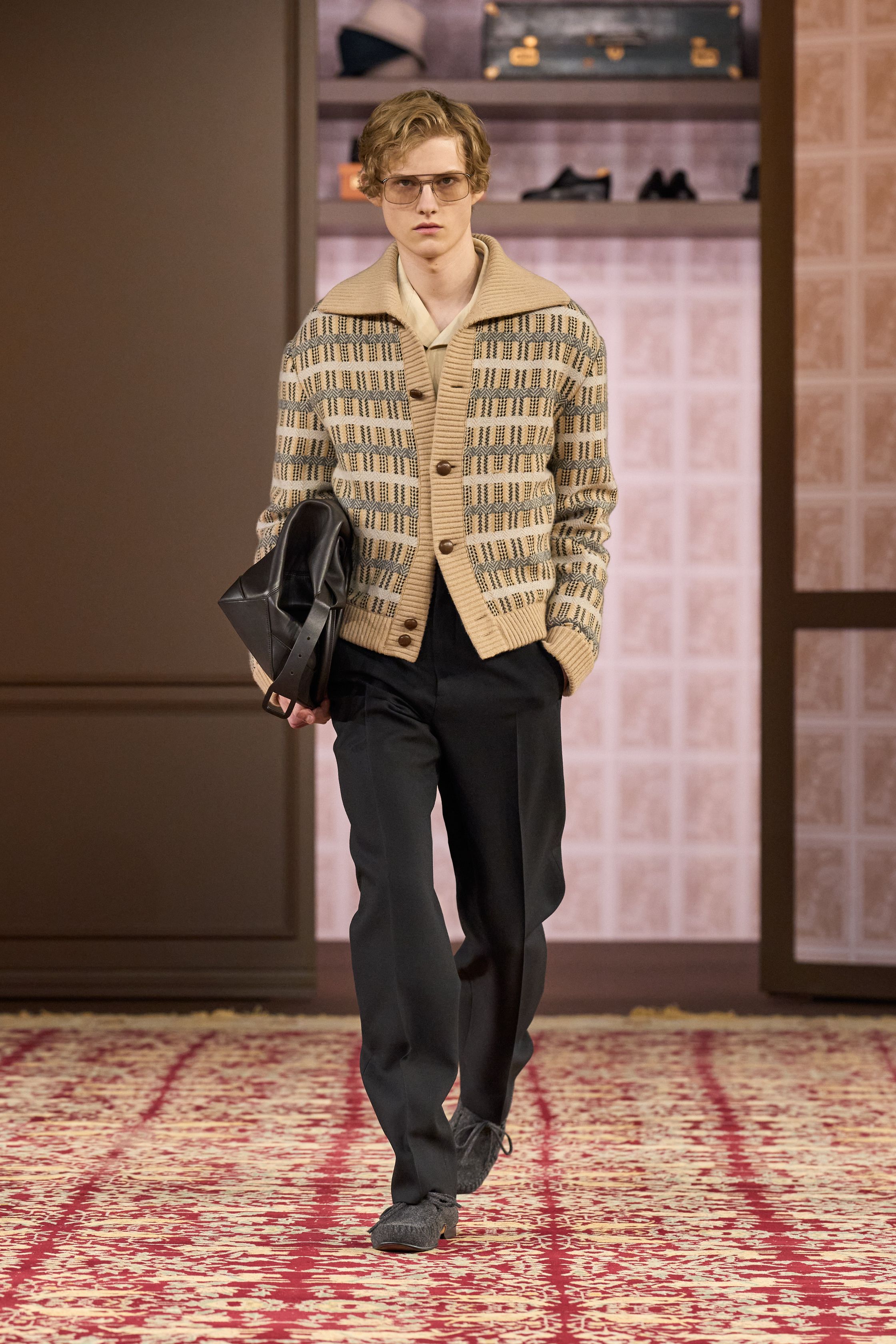 ZEGNA 2026秋冬以“安静权威”为核心命题，在高度私密、近乎沙龙式的空间中重塑当代男性精英形象。柔和灯光下，西装、大衣与针织被处理得异常克制，廓形松弛却精准，强调肩线的自然下垂与裤装的流动垂感。羊毛、羊绒与精纺面料成为绝对主角，色彩集中于驼色、烟灰、深橄榄与夜黑，传递一种无需证明的自信。这一季ZEGNA不谈趋势，而是提出一种长期有效的男性着装秩序——成熟、内敛、经得起时间审视的“当代绅士体系”-顽石频道趋势研究